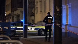 Ein Polizeibeamter steht in der Nähe des abgesperrten Tatorts in Bremen.