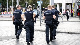 Einsatzkräfte der Polizei laufen über den Bahnhofsvorplatz in Bremen.