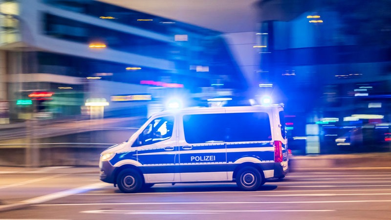 Polizeifahrzeug mit Blaulicht bei Nacht.