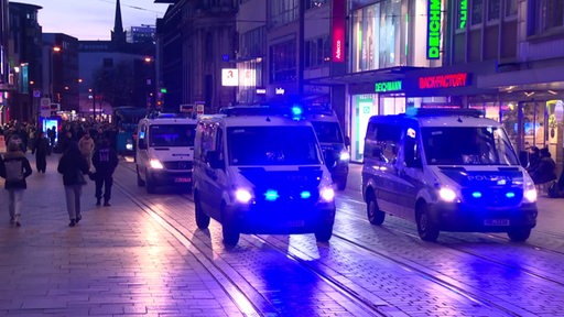 Mehrere Polizeiautos eskortieren einen Demonstrantionszug durch die Bremer Innenstadt