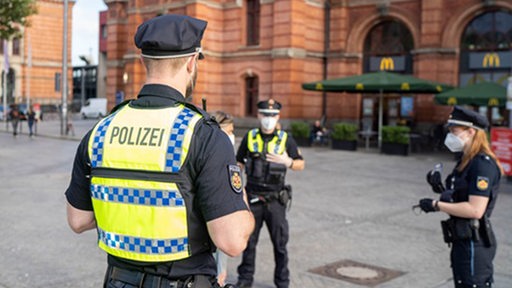Polizist steht in einer Gruppe mit Kollegen vor dem Bremer Hauptbahnhof