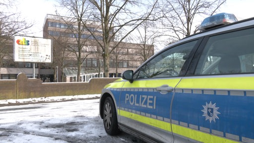 Ein Polizeiauto parkt vor der Alwin-Lonke-Schule in Bremen Nord.