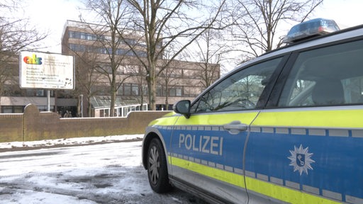 Ein Polizeiauto parkt vor der Alwin-Lonke-Schule in Bremen Nord.