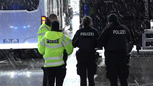 Die Polizei bei starkem Schneefall an einer frisch abgesperrten Unfallstelle.