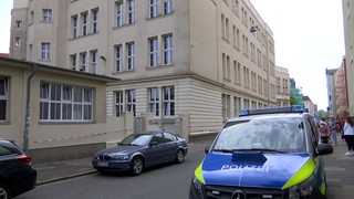 Ein Polizeiauto steht vor einem abgesperrten Schulgebäude in Bremerhaven.