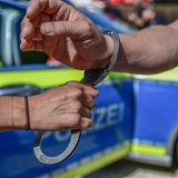 Polizist nimmt Mann in Handschellen fest