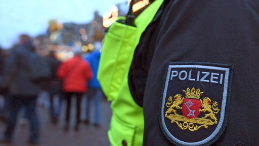 Bremer Polizei - Emblem am Ärmel, im Hintergrund verschwommen Menschen
