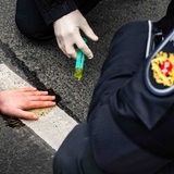 Einsatzkräfte der Polizei lösen den Klebstoff, mit dem sich eine Aktivistin der Letzten Generation am Rembertiring festgeklebt hat. 