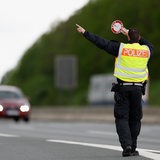 Polizist zieht Fahrzeuge zum kontrollieren aus dem Verkehr.