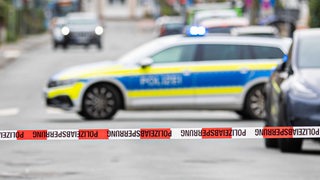 Flatterband der Polizei sperrt eine Straße in Nienburg ab, im Hintergrund ein Einsatzfahrzeug