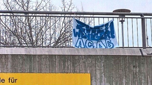 Ein polizeifeindliches Transparent hängt an einer Brücke nahe der Bremer Universität