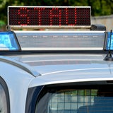 Auf einem Polizeiauto steht eine "Stau"-Leuchtschrift