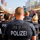 Polizisten gehen über ein Volksfest.