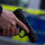 Ein Polizist hält eine Pistole vom Typ Walther P99 in den Händen.