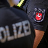 Polizist mit Warnweste und Logo des Bundesland Niedersachsen im Einsatz.
