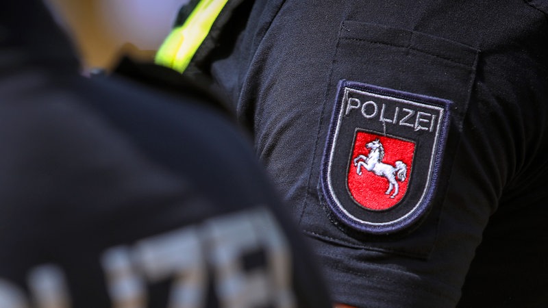 Polizist mit Warnweste und Logo des Bundesland Niedersachsen im Einsatz.