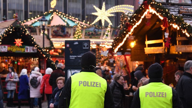 Polizisten laufen über den Bremer Weihnachtsmarkt.