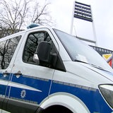 Ein Polizeiauto steht vor dem Weser-Stadion. Im Hintergrund sind die Flutlichtmasten des Stadions zu sehen