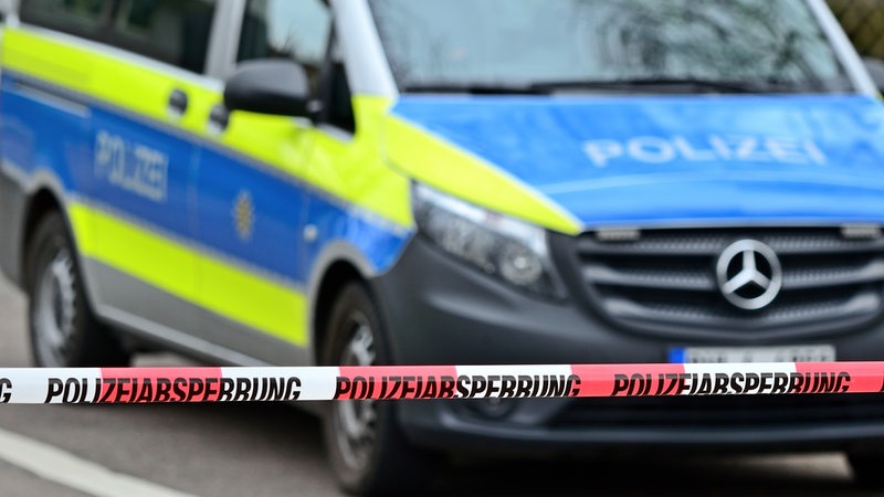Symbolbild "Polizeiabsperrung" Ein durch die Polizei abgesperrter Bereich, dahinter ein Einsatzfahrzeug der Polizei.