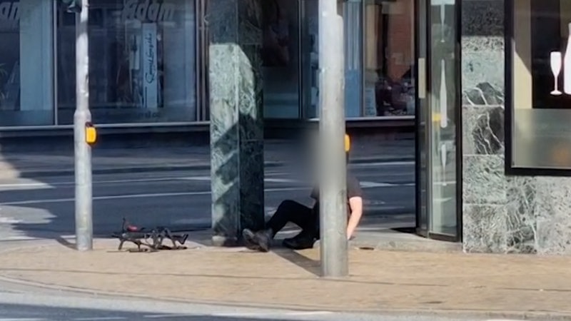 Ein Mann sitzt in der Bremerhavener Innenstadt auf dem Boden.