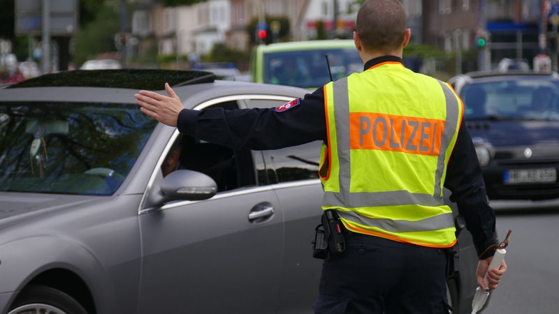 Ein Polizist winkt einen Verkehrsteilnehmer heraus