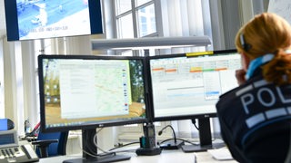 Eine Polizistin sitzt in einem Büro am Computer
