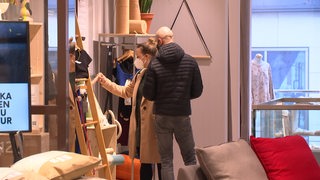 Ein Pärchen steht in einem Concept-Store und schaut sich etwas an.
