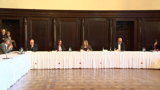 Im Bremer Rathaus sitzen der Bürgermeister und mehrere Senatoren an einem Tisch.