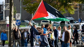 Teilnehmer einer pro-palästinensischen Demonstration protestieren für Solidarität mit Gaza und schwenken Palästinenser-Flaggen.