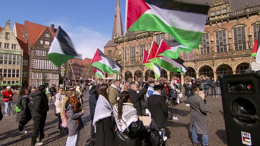  Eine Pro-Palästinensische Demonstration auf dem Bremer Marktplatz. Mehrere Personen haben Fahnen dabei.