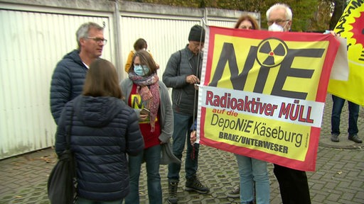 Menschen protestieren mit Bannern und Fahnen gegen Atomenergie und Atomkraftwerke.