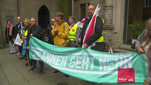 Zu sehen sind mehrere Protestanten, welche ein Banner halten, auf welchem "zusammen geht mehr steht".