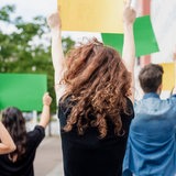 Menschen von hinten protestieren (Symbolbild)