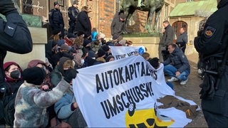 Aktivisten blockieren den Eingang zum Rathaus.
