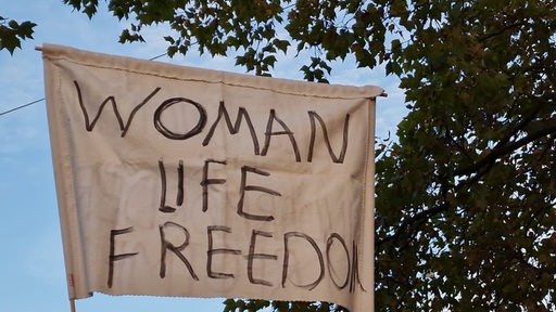 Auf einem Transparent steht: "Woman Life Freedom".