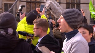 Ein Demonstrant schreit auf dem Bremer Marktplatz.