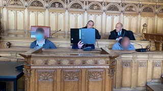 3 Angeklagte und Verteidung im Gerichtssaal
