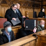 Die Angeklagten sitzen vor Prozessbeginn im Gerichtssaal. Die Staatsanwaltschaft wirft drei Verdächtigen aus der rechtsextremistischen Szene einen Brandanschlag auf ein Bremer Jugendzentrum vor.