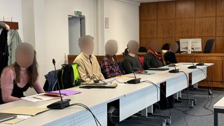 6 verpixelte Gesichter der angeklagten Klima-Aktivisten im Amtsgericht Bremen.