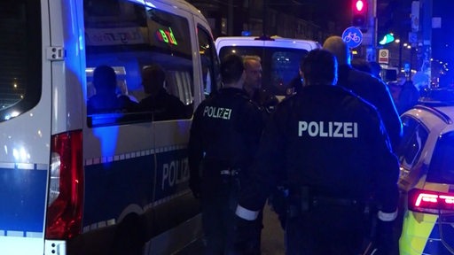Mehrere Polizisten und Polizeiautos am Tatort in der Bremer Neustadt. 
