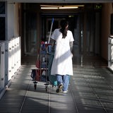 Eine Putzkraft läuft durch ein Krankenhaus.