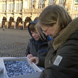 Eine Frau und ein Kind puzzeln auf dem Bremer Marktplatz.