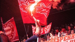Ein München-Fan zündet im Bremer Weser-Stadion Pyrotechnik.