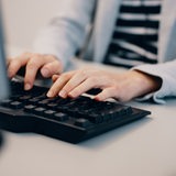 Eine Frau schreibt auf einer Computer-Tastur