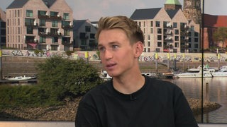 Radprofi Lennard Kämna sitzt im Sportblitz-Studio beim Interview.