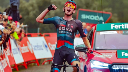 Radprofi Lennard Kämna reckt jubelnd die Faust hoch bei seinem Etappensieg bei der Vuelta.