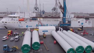 Raketenteile warten in einem Hafen darauf auf ein wartendes Schiff verladen zu werden.