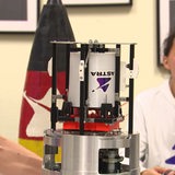 Zwei Männer, einer von ihnen baut an einer Rakete.