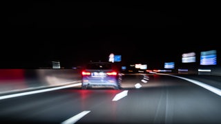 Ein Auto fährt bei Nacht auf der Autobahn.