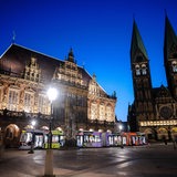 Das Rathaus Bremen, daneben der Dom. Im Vordergrund fährt eine Straßenbahn.